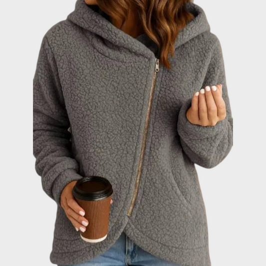 Gray teddy textured hooded jacket with a curved hem, long sleeves, and diagonal front zip closure, styled with jeans.