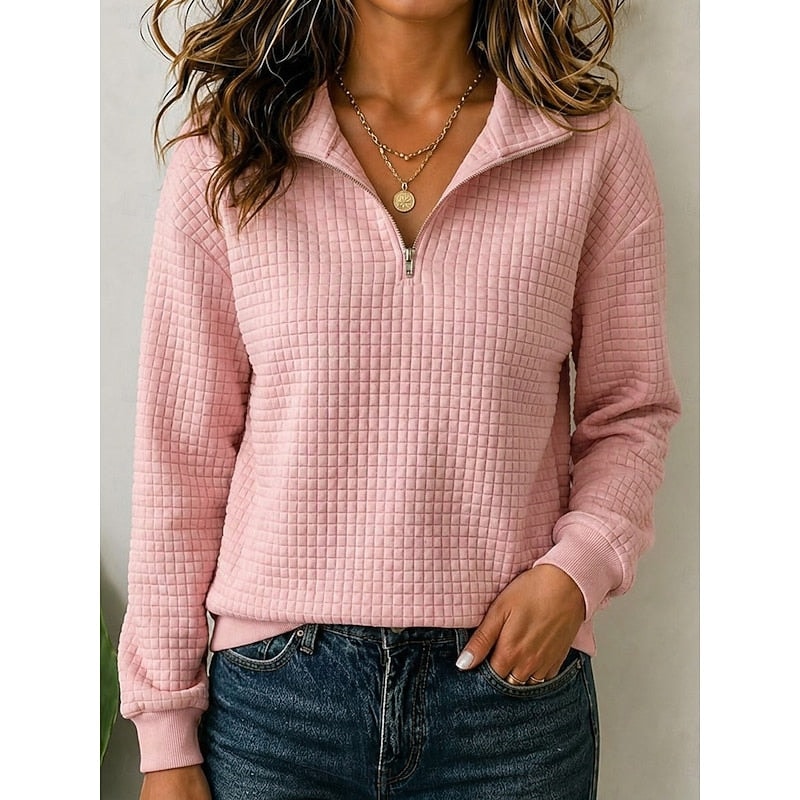 Pink textured quarter-zip pullover styled with the zipper partly open, long sleeves, and a neat ribbed hem.