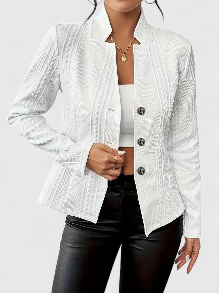 White textured single-breasted blazer with a notched collar, long sleeves, and three-button front worn with black trousers.