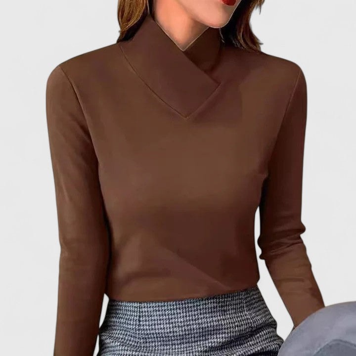 Chocolate brown fitted turtleneck top with an asymmetric folded neckline paired with a patterned skirt.