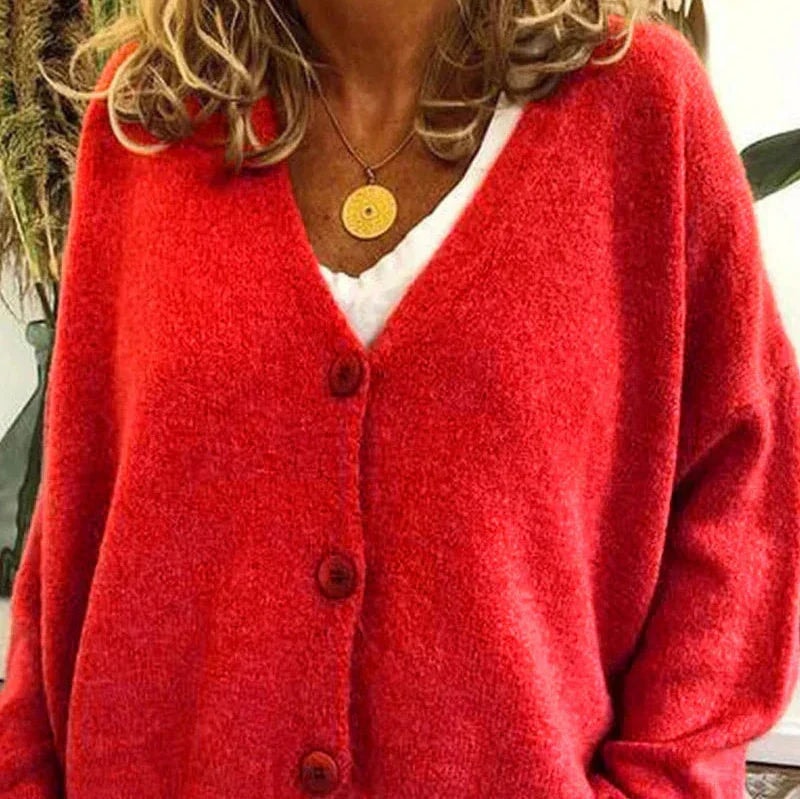 Vibrant red cardigan with a V-neckline and button-front closure, worn over a white top.