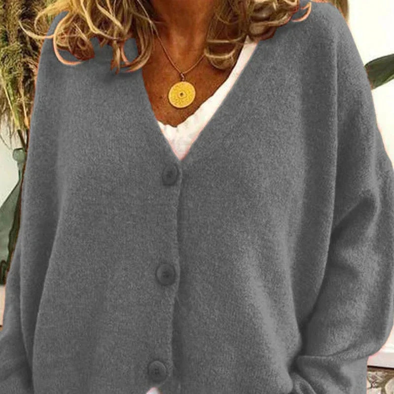 Gray V-neck cardigan layered over a white top, with dark buttons running down the front.