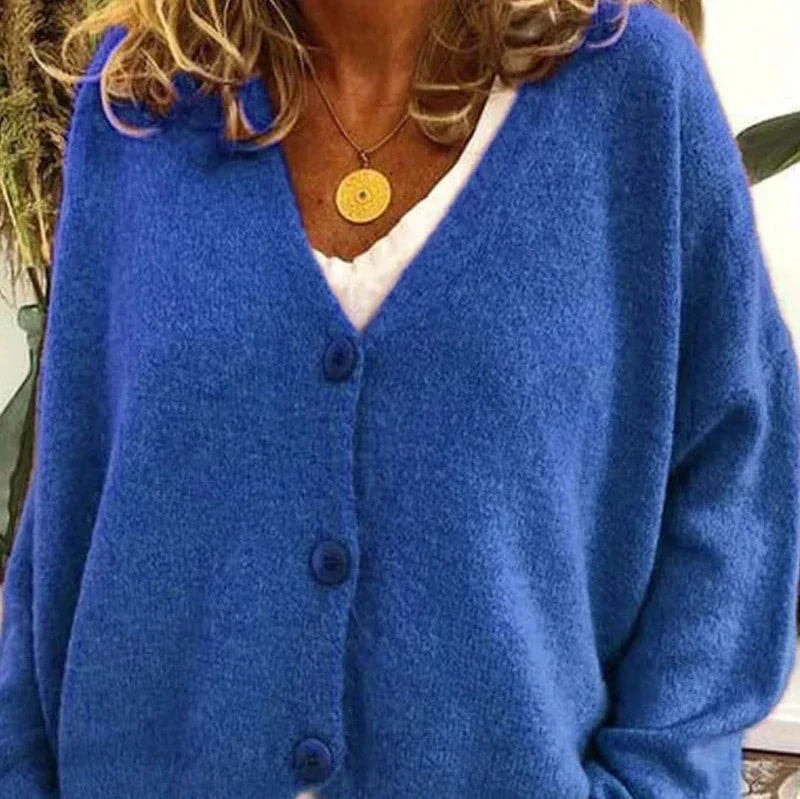 Bright blue button-front cardigan with a V-neck and long sleeves, styled over a white top.