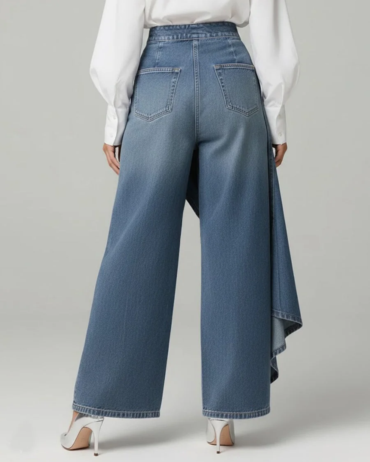 Back view of blue wide-leg wrap trousers showing the high waistband, two back patch pockets, wide hems, and the overlapping wrap panel extending along one side.