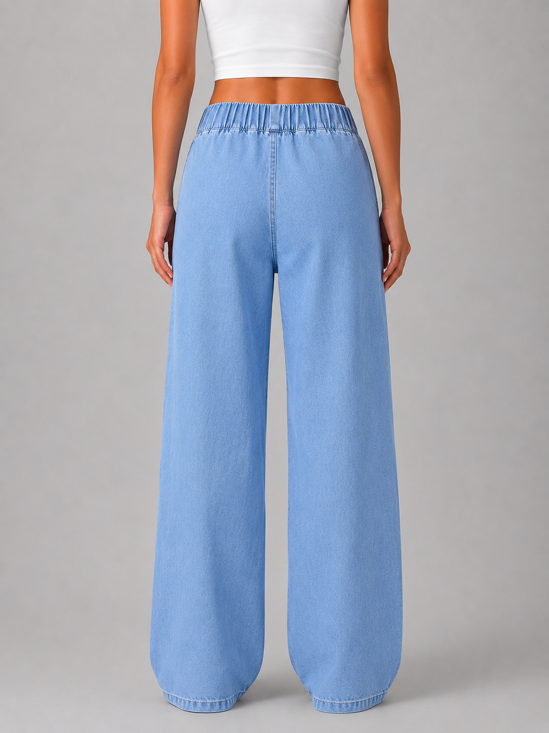 Back view of light blue full-length wide-leg jeans showing the relaxed shape and gathered elasticated waistband.
