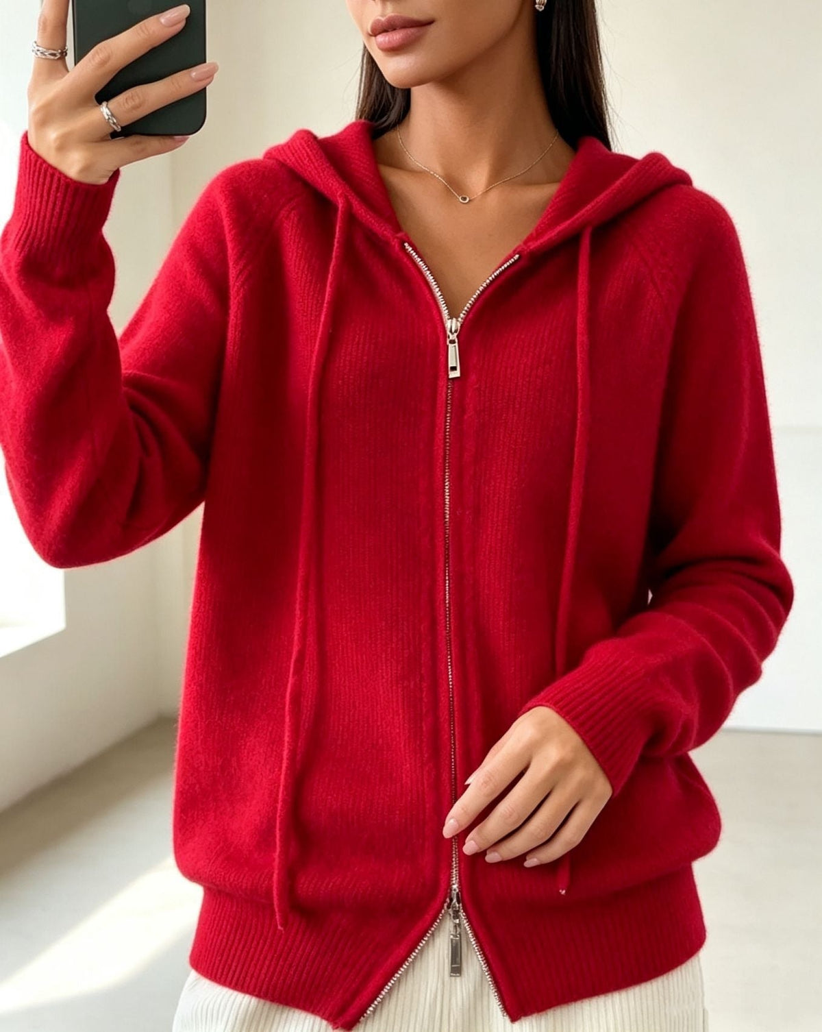 Red zip-up hooded cardigan with drawstrings, long sleeves, ribbed cuffs and hem, shown partially zipped.