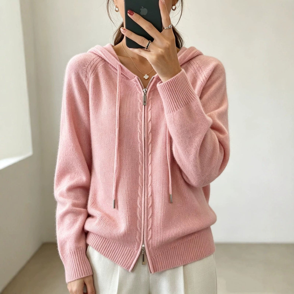 Soft pink hooded cardigan styled with the zipper closed, long sleeves and a relaxed ribbed finish.