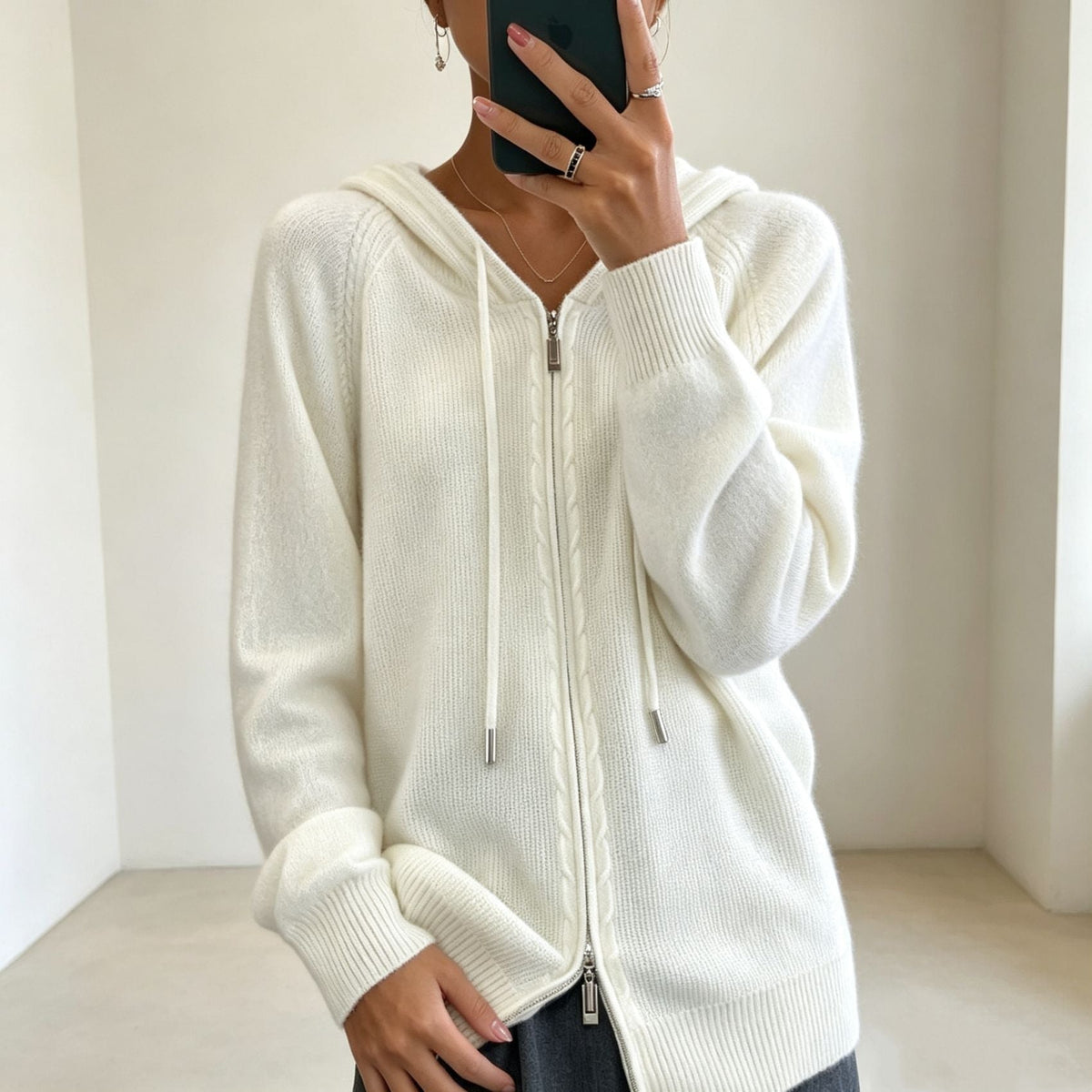 Off-white zip-up hooded cardigan with a front zipper, drawstring hood and ribbed hem.